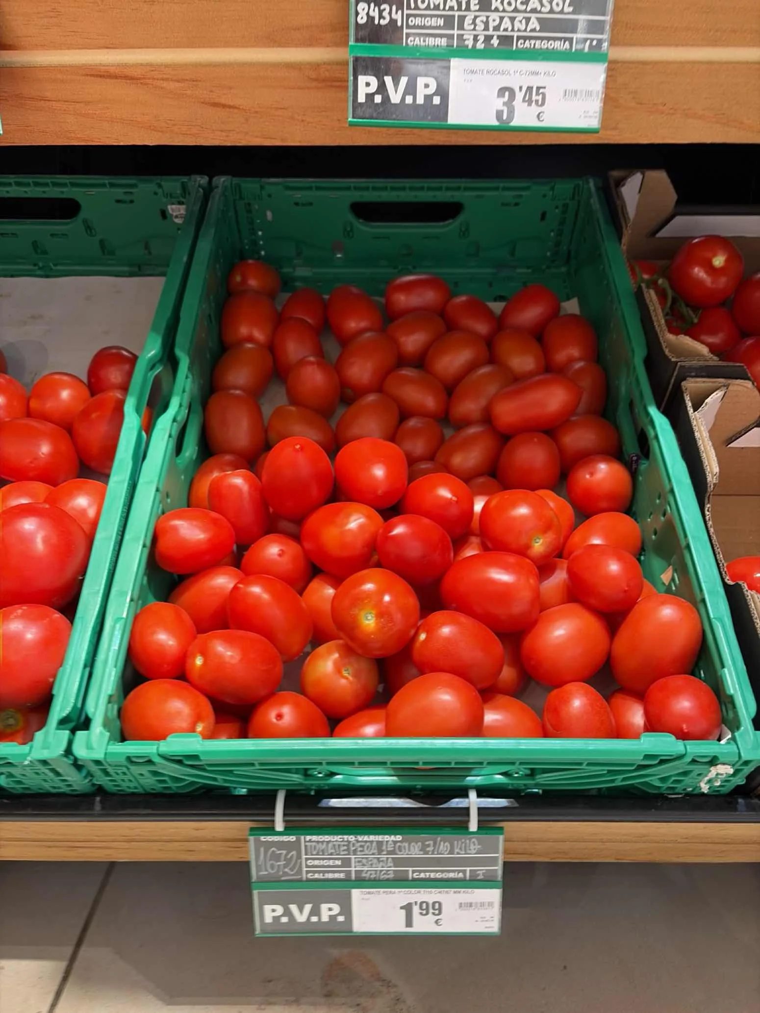 Round tomatoes in crates on a retail shelf